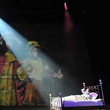 A performance of "Angels In America" at Carnegie Mellon. Bright beam of light on Prior Walter in bed as he is visted my digital images of ghost.