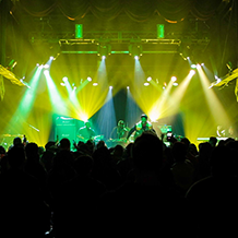 Hip Hop artist B.o.B performing in front of purple and green beams of light at a concert with DJ Shawty Slim.